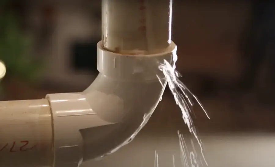 Water spraying from a cracked pipe fitting in a Framingham home